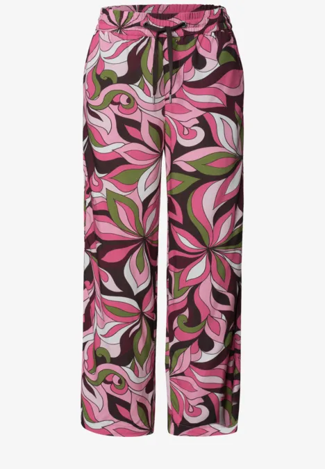 Wijde palazzo-broek in roze, groen en zwart met abstract bloemmotief.