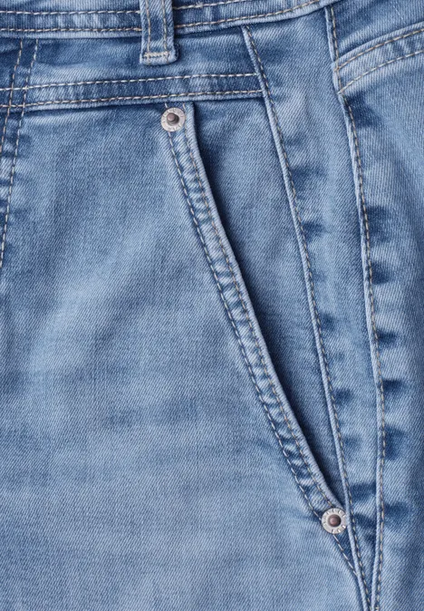 High Waist Barrel Leg Jeans im Loose Fit Light Blue Wash Detail einer hellblauen Jeanshose mit schräger Vordertasche und Metallnieten.