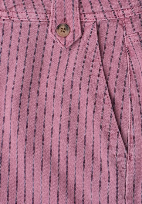 Close-up van een roze broek met zwarte strepen, knoop en zijzak.