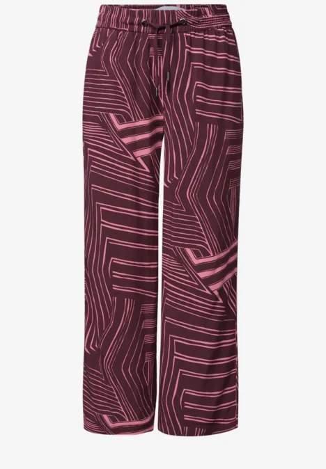 Pantalon ample bordeaux à motif géométrique rose.