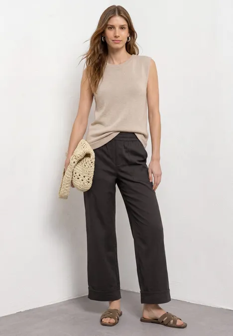 Straight Leg Hose im Casual Fit mit Turn-Up black coffee Frau trägt beiges ärmelloses Top, weite schwarze Hose, Sandalen und gehäkelte Tasche.