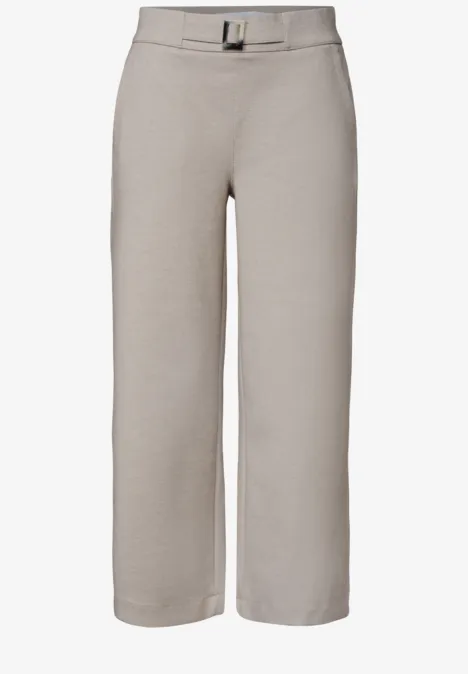 Lichtbeige wijde enkellange broek met hoge taille, plooien vooraan en bijpassende riem.