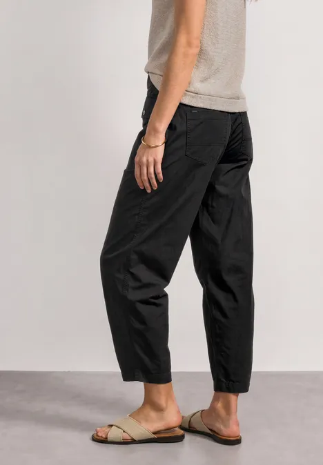 Pantalon noir ample et sandales claires, style décontracté
