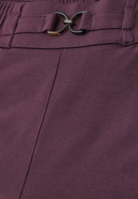 Slim Leg Hose mit Schnallendetail rustic rouge Nahaufnahme eines violetten Kleidungsstücks mit Ziernaht und goldfarbenem Schnallendetail.