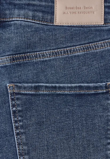 High Waist Barrel Leg Jeans im Loose Fit Mid Blue Random Washed Nahaufnahme von blauen Jeans mit Gesäßtasche und Lederetikett am Bund.