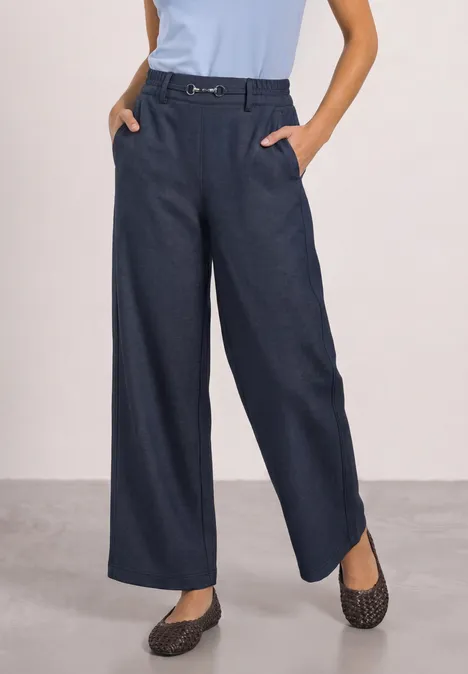 Straight Leg Hose mit Schnallendetail darkest blue Frau trägt dunkelblaue, weite Hose mit Gürtel, hellblaues Top und gemusterte Hausschuhe.
