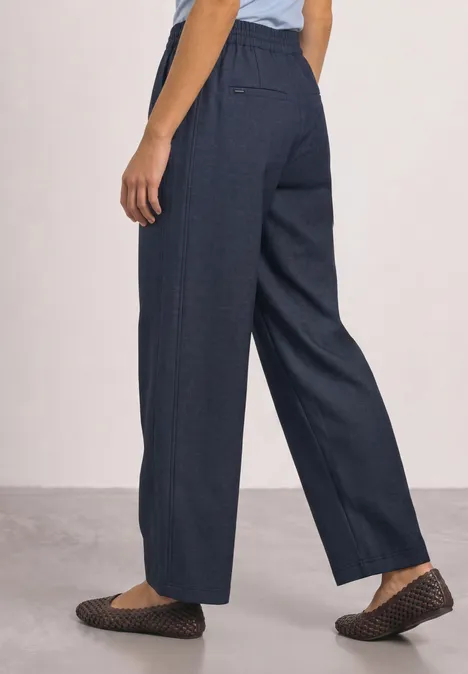 Straight Leg Hose mit Schnallendetail darkest blue Seitliche Ansicht einer Person mit weiten, dunkelblauen Hosen und strukturierten schwarzen Slippern.
