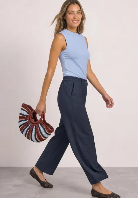 Straight Leg Hose mit Schnallendetail darkest blue Eine Frau in hellblauem Top und dunkelblauen, weiten Hosen mit gestreifter Tasche.