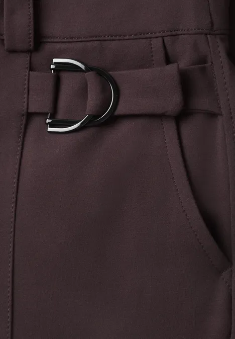 Nahaufnahme eines dunkelbraunen Hosenbunds mit seitlicher Tasche und D-Ring-Gürtel.