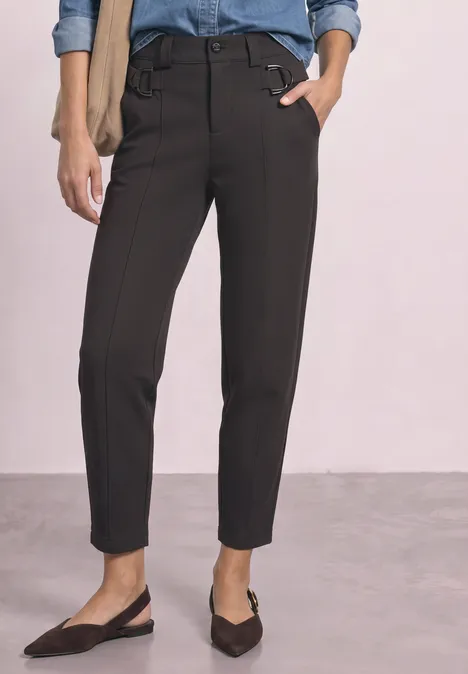 Schwarze, schmal geschnittene Ankle-Hose mit hohem Bund, kombiniert mit flachen Slingback-Pumps.