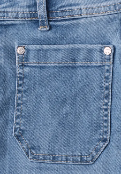 Close-up van een blauwe jeans met zichtbare zak en stiksel.