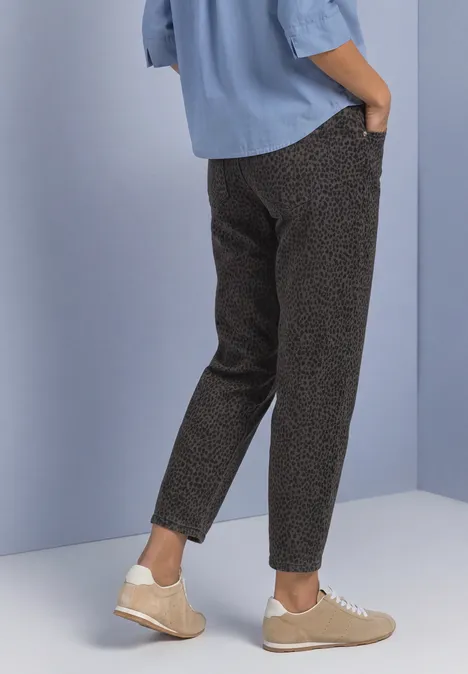 High Waist Barrel Leg Jeans im Loose Fit brown leo washed Schlanke gemusterte Hose, hellblaues Hemd und beige Sneaker, vor hellem Hintergrund.