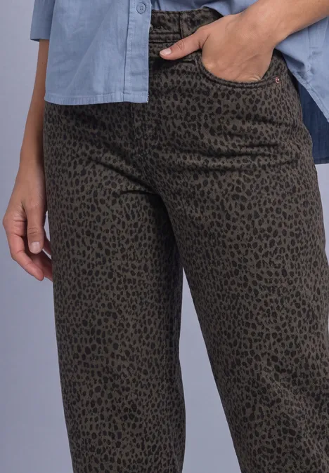High Waist Barrel Leg Jeans im Loose Fit brown leo washed Person trägt olivgrüne Hose mit schwarzem Leopardenmuster, Hand in Tasche, hellblaues Hemd sichtbar.