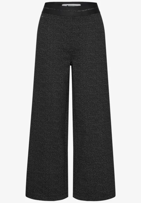 Zwarte, wijde broek met hoge taille en losvallende pijpen.