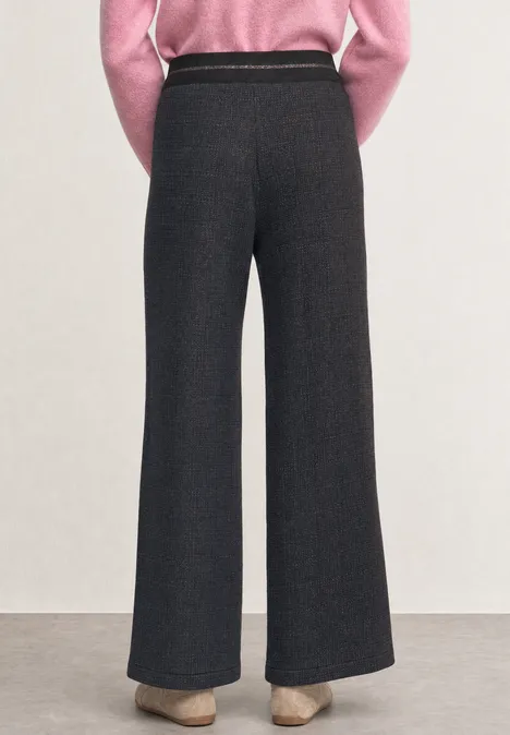 High Waist Wide Leg Hose in Strick-Optik indigo night Rückansicht einer Person in hochtaillierter, dunkelgrauer, weiter Hose und beigefarbenen Absätzen.