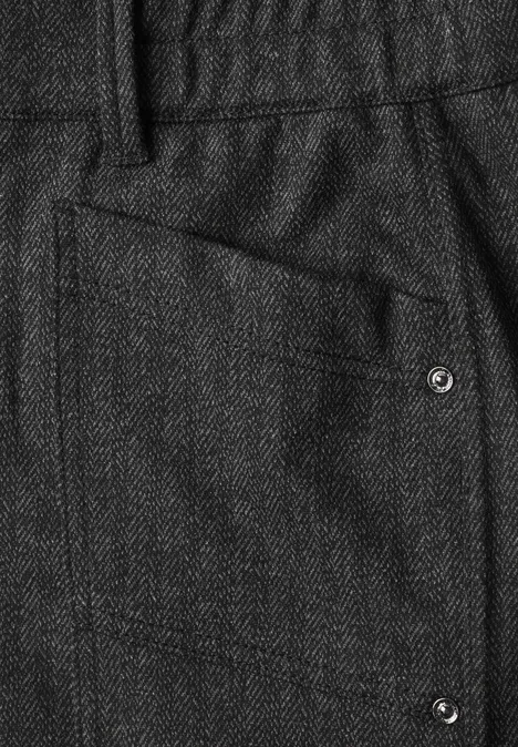 Dunkelgraue Hose mit strukturiertem Stoff, aufgesetzter Tasche und silbernen Nieten.