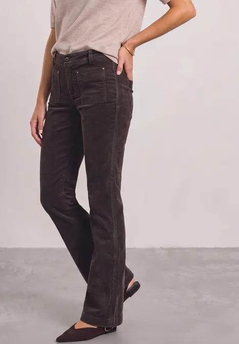 Pantalon bootcut taille haute à coupe ajustée ruby vine Person trägt dunkelbraune Cordhose und hellgraues T-Shirt, Blick auf den Unterkörper.