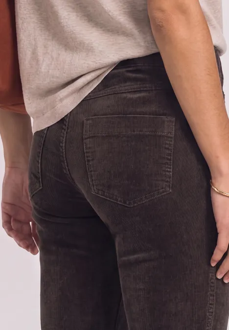 Pantalon bootcut taille haute à coupe ajustée ruby vine Nahaufnahme einer Person von hinten in dunkelgrünen Röhrenjeans und hellem Top.