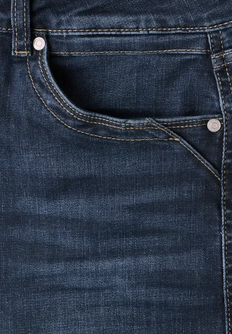 Dunkle Jeans mit sichtbarem Tascheneingriff, Nahtdetails und silbernen Nieten.
