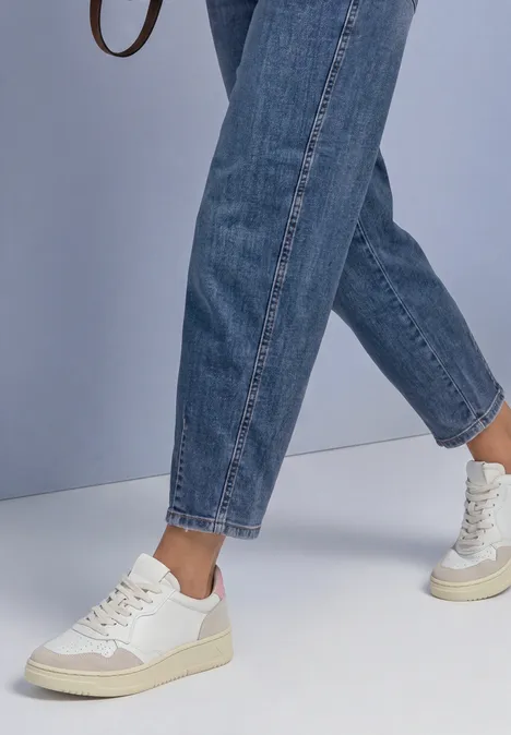 Jeans met High Waist en rechte pijpen in een Loose Fit-pasvorm Medium Blue Soft Washed Schlichtes Outfit mit weißen Sneakers und blauen Jeans vor hellem Hintergrund