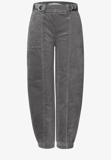 Graue Cordhose mit hohem Bund, Gürtel, seitlichen Taschen und schmal zulaufenden Beinsäumen.