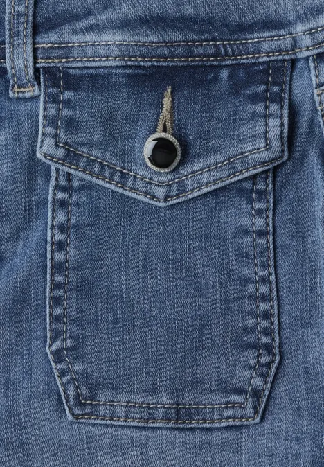 High Waist Bootcut Jeans im Slim Fit Mid Blue Washed Blauer Jeansstoff mit aufgesetzter Tasche und Metallring als Verschluss.