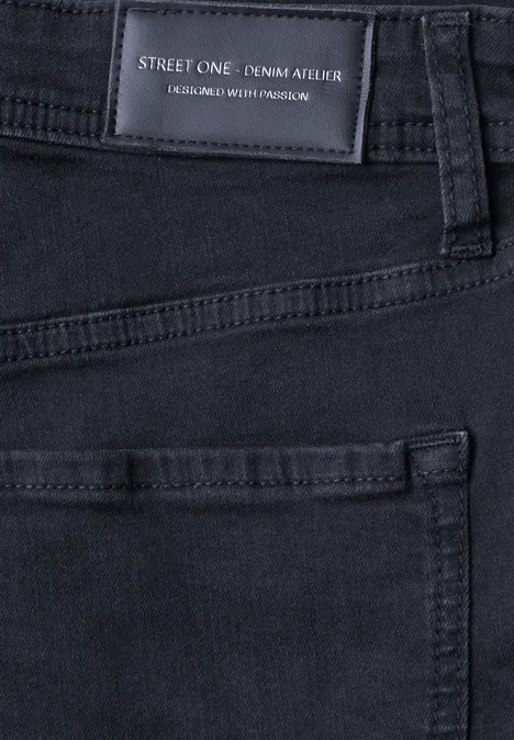 Nahaufnahme einer schwarzen Jeans mit sichtbarem Label und Taschennaht.