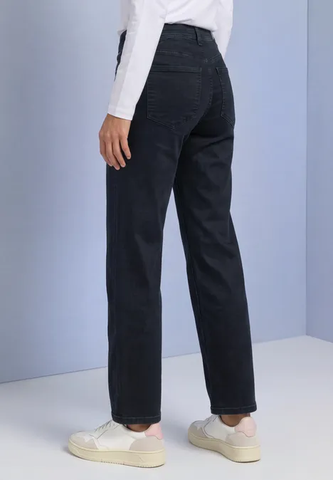 Mid Waist Straight leg Jeans im Casual Fit blue black soft wash Schlicht geschnittene schwarze Hose in geradem Schnitt, kombiniert mit weißen Sneakers und lockerem Oberteil.