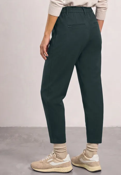 High Waist Barrel Leg Hose im Casual Fit stormy green Dunkelgrüne, hoch taillierte, gerade geschnittene Hose, kombiniert mit hellen Sneakers und Socken