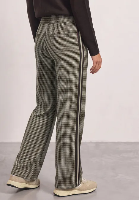 Wide Leg Hose mit Gallonstreifen und Dessin sanded amber Rückenansicht einer Person mit weiten karierten Hosen, seitlichem Streifen und hellen Sneakern