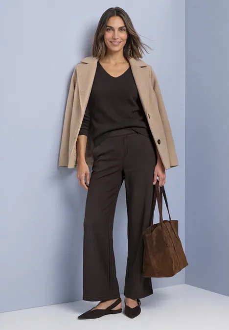High Waist Wide Leg Hose im Casual Fit black coffee Frau in Business-Look mit beigem Blazer, schwarzem Top, weiten Hosen, Ballerinas und brauner Tasche.