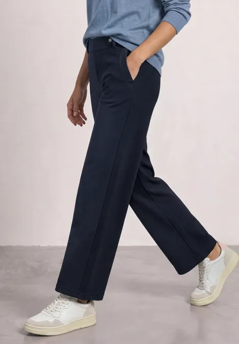 High Waist Wide Leg Hose im Casual Fit darkest blue Person trägt weiße Sneaker und weite, dunkelblaue Hose, steht vor schlichten Hintergrund