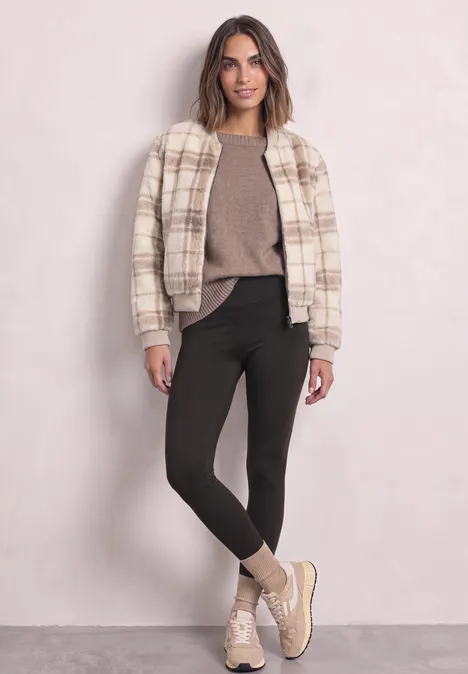 Thermo-Leggings im Skinny Fit black coffee Eine Frau trägt eine karierte Jacke, einen braunen Pullover, schwarze Leggings und bequeme Sneakers.
