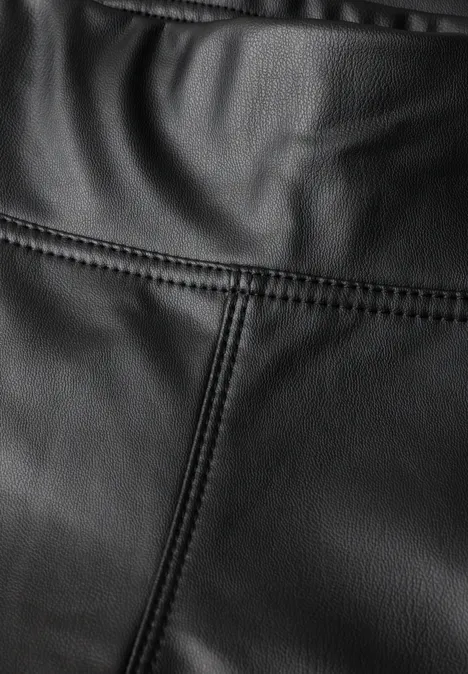 Close-up van zwart leer met zichtbare stiksels en fijne textuur.