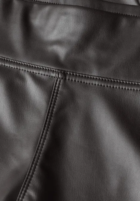 Nahaufnahme von schwarzem Leder mit akkuraten Nähten und sichtbarer Textur.