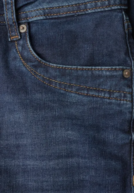 Nahaufnahme einer blauen Jeans mit sichtbarer Tasche, Nahtdetails und Metallnieten.