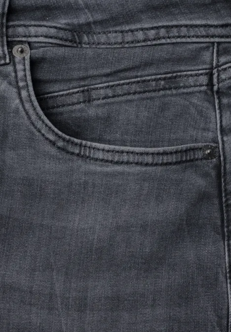 Nahaufnahme einer dunklen Jeanshosentasche mit Naht und Münztasche.