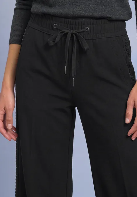Zwarte, losse broek met wijd broekspijp en taillekoord.