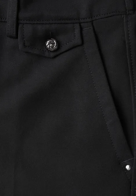 Detail einer schwarzen Tasche mit Klappe, silbernem Druckknopf und kleiner Niete.