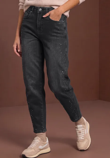 Jean taille haute à Barrel Leg, coupe ample grey washed Person trägt schwarze Jeans und beigefarbene Sneaker vor braunem Hintergrund