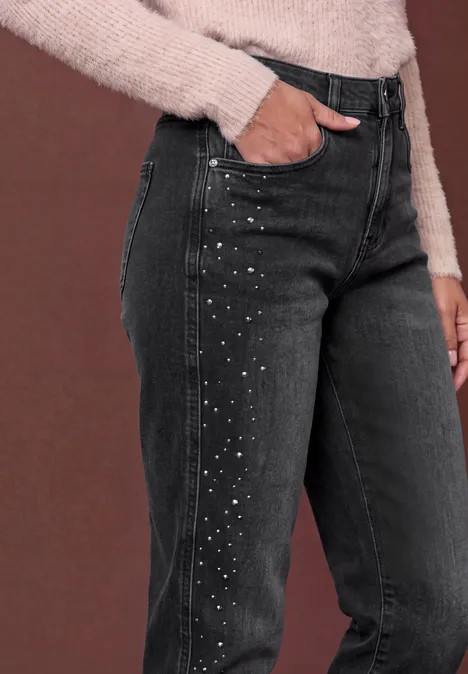 Jean taille haute à Barrel Leg, coupe ample grey washed Schwarze Jeans mit seitlichen Strassstein-Details, kombiniert mit einem beigen Strickpullover.