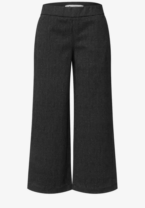 Pantalon noir taille haute, coupe ample à jambe large.