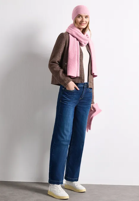 Feinstrick Beanie in Unifarbe vintage blush mel. Junge Frau in Jeans, brauner Jacke und rosa Mütze mit passendem Schal und Tasche.