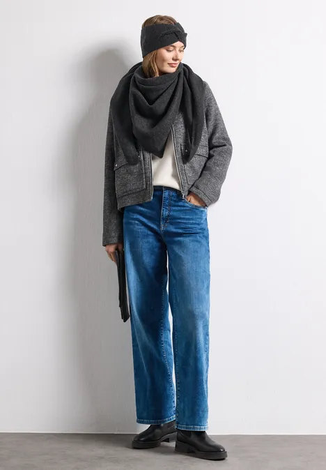 Fijngebreide driehoekige sjaal in effen kleur anthracite melange Vrouw in casual winteroutfit met zwarte muts, grijze jas, wijde blauwe jeans en sjaal.