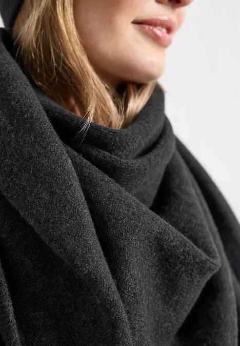 Fijngebreide driehoekige sjaal in effen kleur anthracite melange Close-up van een persoon met een zwarte sjaal, focus op lippen en hals