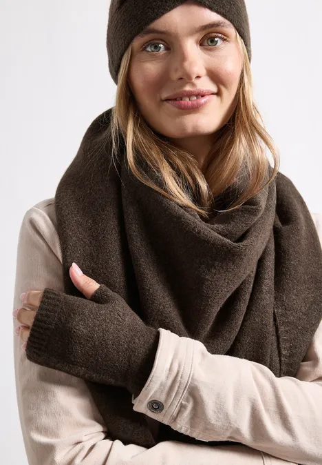 Feinstrick Armwärmer in Unifarbe auburn brown mel. Eine junge Frau trägt eine braune Mütze, einen dicken Schal und ein beiges Shirt mit Daumenlöchern.