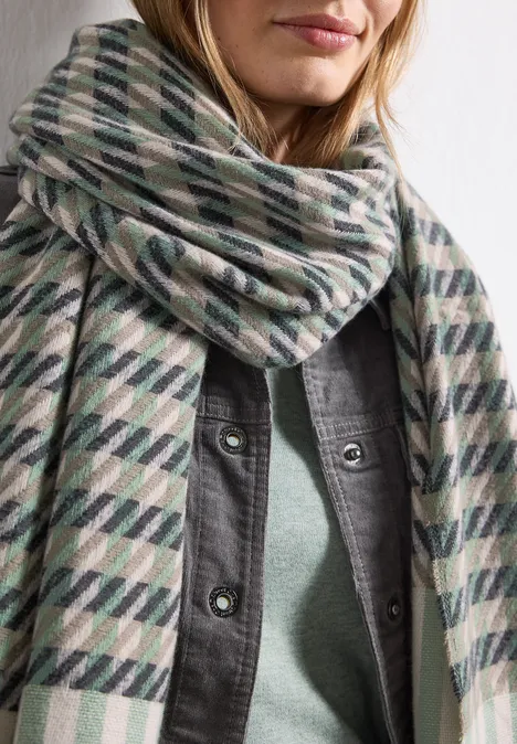 Sjaal met houndstooth-patroon Fresh Sage Persoon met een geruit grijs-groen-wit sjaal over een grijs overhemd.
