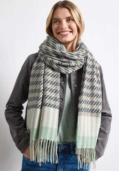 Sjaal met houndstooth-patroon Fresh Sage Lachende vrouw met geruite sjaal en leren jas, moderne winterlook.
