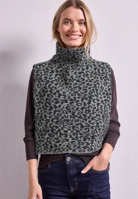 Jacquard Kragen mit Leo-Muster Black Frau trägt graue Leo-Rollkragenweste über dunklem Langarmshirt, lächelt entspannt, Hände in Jeans-Taschen.