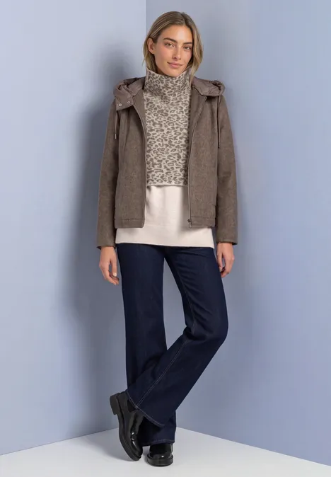 Jacquard Kragen mit Leo-Muster barley beige mel. Eine Frau trägt eine braune Kapuzenjacke, cremefarbenen Pullover, weite Jeans und schwarze Schuhe vor hellem Hintergrund.